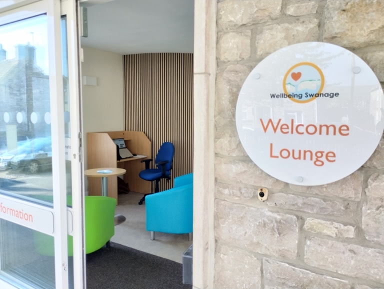 Photo of the wecome lounge, taken from the doorway, looking in to comfortable sofas and a friendly welcoming space for people to visit.